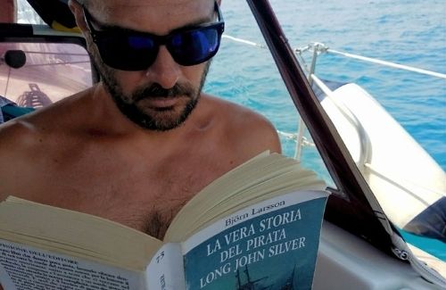 Il comandante legge un libro in barca a vela