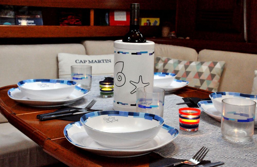 Foto di una tavola apparecchiata con un servizio di piatti in plastica dura, regalo per velisti perfetto