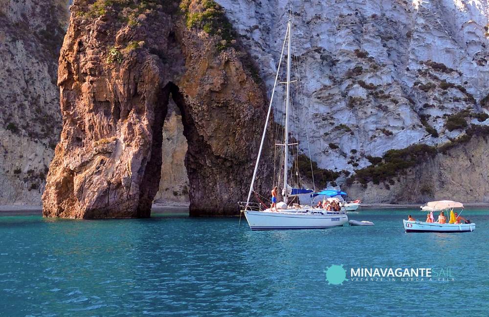 Foto di una barca a vela davanti all’Arco Naturale, una delle baie di Ponza, alle isole Pontine