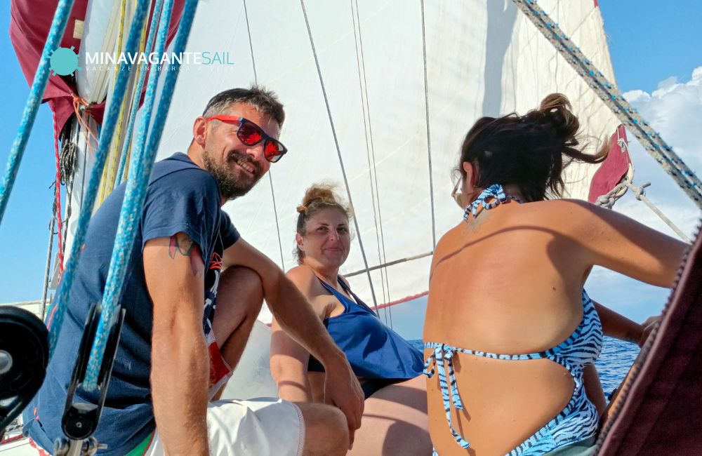 Foto di un ragazzo e due ragazze a bordo di Mina Vagante 2, durante la loro esperienza in barca a vela