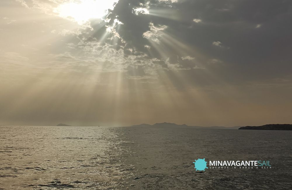Foto di una baia in Sardegna con il sole che esce dalle nuvole dopo un pomeriggio di cattivo tempo